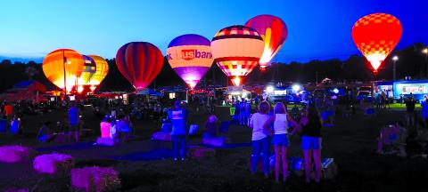 The feels-like heat values continue to top 100 degrees in Northern Kentucky, but that didn’t stop people from turning out festivals and events in Pendleton County. Two of them included the second annual Balloons and Tunes on Saturday at the Kentucky Wool Festival Grounds, above. This photo shows some of the 10 grounded hot air balloons that were lit up at dusk for a balloon glow. The family-oriented event also included bands, food trucks and a kids play area. Photo by Sam McClanahan.