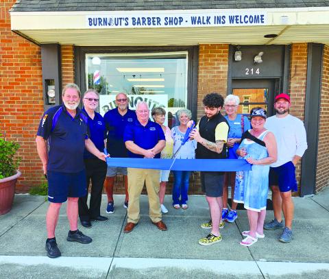 Joining Garrad Dennie for the official ribbon-cutting July 25 for Burnouts Barber Shop in Falmouth are, from left, his dad Gary Dennie, Pendleton County Chamber of Commerce Vice President Neil Belcher, Chamber member Randy Wells, Chamber President Gary Hicks, family friend Dixie Wells, Pendleton County Director of Economic and Tourism Development Tami Vater, Garrad Dennie, family friend Kim King, mom Dina Dennie and brother Josh Plummer. Photo by Burton Cole.