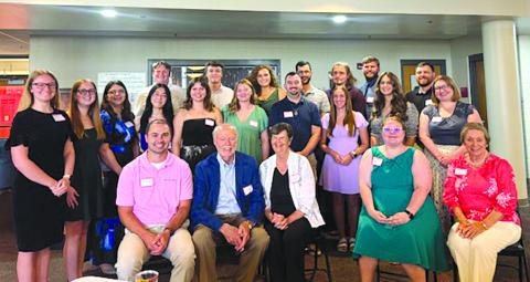 Sharp Scholarship recipients in attendance at the July 25 debut of the documentary “Cracking the Code: Phil Sharp and the Biotech Revolution” are, front row from left, Bryan Woods (2012), Dr. and Mrs. Sharp, Kitrina Justus (2018), Carol Klaber, Sharp Scholarship contact; second row, Shelby Eckart (2022), Emily Best (2025), Alexandria Black (2024), Annie Lin (2025), Allie Redden (2021), Grace Beebe (2017), Jared Wolfe (2016), Calliope Warren (2024), Savannah Schlueter Monroe (2012)  and Dr. Mariah Moore (201