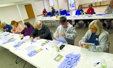 Pendleton County Retired and Senior Volunteer Program members worked a service project Monday morning with Disabled American Veterans, affixing 3,000 forget-me-knots to thank-you cards to be mailed to veterans. Today, Nov. 11, is Veterans Day,  a day to honor veterans of the United States Armed Forces. Photo by Lisa Wiggins.