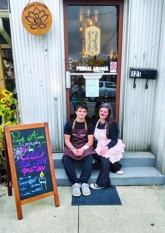 Ashley Cassidy, right, sits beside her son, Wyatt, in front of Primal Aroma and Co., 121 W. Shelby St., Falmouth. The store carries products made from natural ingredients including candles and cosmetics. Photo courtesy of Ashley Cassidy.