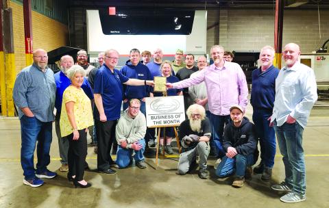 In the photo, kneeling from left are Paragon employees Jordan Antrobus, Mark Murphy and Tom Meyer. In the second row are Tami Vater, Pendleton County economic and tourism development director, and Neil Belcher, chamber president, who is handing the Business of the Month plaque to brothers and owners of Paragon, Matthew, Jason and Bryan Muehlenkamp. In the third row are Randy Wells and Doug Buckner of the Chamber, and Paragon employees Joey Clos, Jonathan Pugh, Opal Bills and Mike Antrobus. The fourth row is