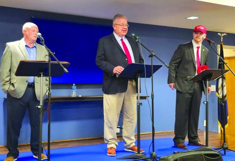 Rick Mineer, left, and Sebastian Ernst, right, listen as Anthony Strong answers a question during the Pendleton County Farm Bureau’s Measure the Candidates event April 8 at the Pendleton County Cooperative Extension Office. The three men, along with Jimmy Poynter, are vying for the Republican Party nomination for county judge executive on the May 19 primary election. Since no one filed for the Democratic nomination, the winner of the primary is virtually assured of winning the office in the November general