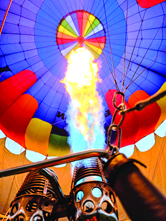A burner shoots heated air inside the bag, or envelope. Hot air is lighter than cool air, which allows the balloon and attached passenger basket to ascend.
