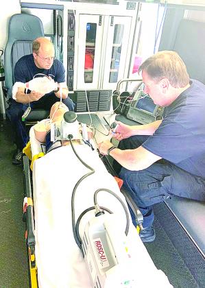 Ken Smith, EMT, and Keith Workman, Paramedic, is working on a practice patient with their new piece of equipment.