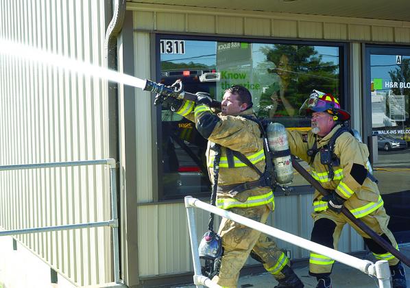 Two Northern Pendleton firefighters handle the hose