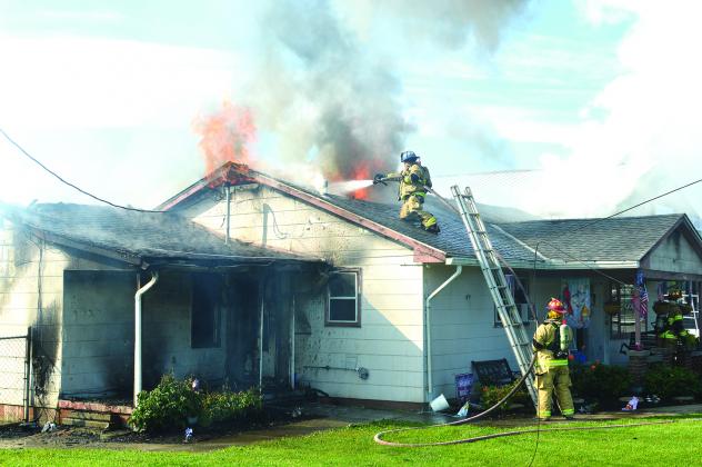 A fireman scaled the roof of the building home to try and get water on the flames