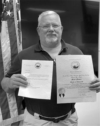 Mike Moore shows off the letter and certificate naming him an Honorary Duke of Hazard for his help during the recent disaster there.