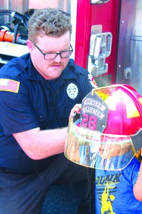 A tyke tries on a fire helmet from Northern Pendleton Fire Department.