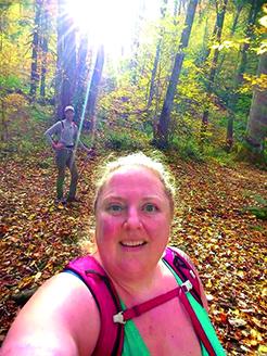 McElfresh and her husband, Tim Richmond, background, hike in the woods. 