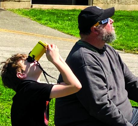 Samuel Pearson, using Sunoculars, and his dad, Joe, of McKinneysburg, watch the solar eclipse from a park in Connersville, Ind., where the eclipse was total. Photo by Hannah Pearson.