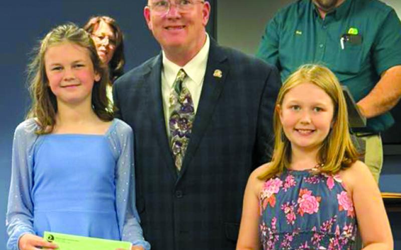 Standing with state Rep. Mark Hart, R-Falmouth, are art contest winners were Amelia Winkle, first place, and Evelyn Applegate, second. Not pictured is third place finisher Finley Thomas.