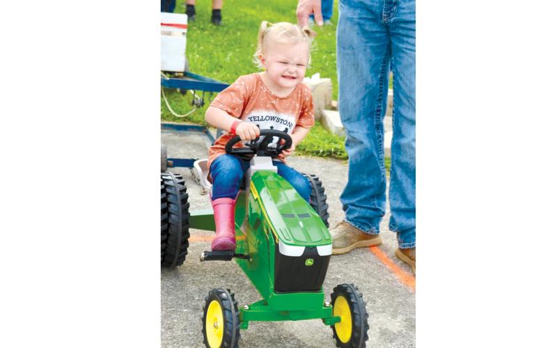 Kyndal Ross puts her all into the Kiddie Tractor Pull. Photo by Lisa Arnold.