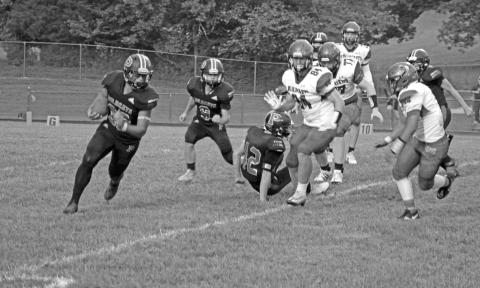 Wildcat Tyler Redden sweeps around the end as Vincent Nocero trails the play against Nicholas County. Photo by Scott Collins 