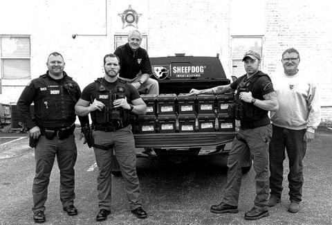 Sheriff Jared Brewer and some of his deputies show off their new medical kits. The kits were delivered by David Jardon of Sheep Dogs Impact Assistance, a group of veterans and first responders who reach out to support in disasters and support each other through Get Off the Couch programming, a volunteer and activity opportunity.  Pictured are, from left to right, Sheriff Jared Brewer, Dep. Nathan Reinhart, Jardon (in truck), Dep. Steve Linville, and Blaine Hagins, another Sheep Dog member.