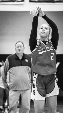 Ladycats sophomore Lilly Ashcraft follows through on her free throw attempt while team head coach Patrick Kelsch looks on. Photo by Pete Wigginton.
