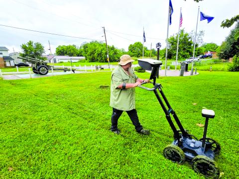It resembles a push lawnmower, but Billy Wilkerson of the Simpson County Historical Society is using a ground-penetrating radar device last Friday at Hardin-Browning American Legion Post 109, 111 Montjoy St., Falmouth. More than 100 years ago, the site was an AME Church graveyard. The cemetery was relocated, but the device detected eight unmarked graves that were overlooked in the move. Photo by D. Franklin.